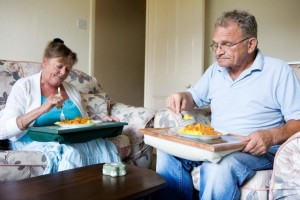 Couple eating a meal in the couch
